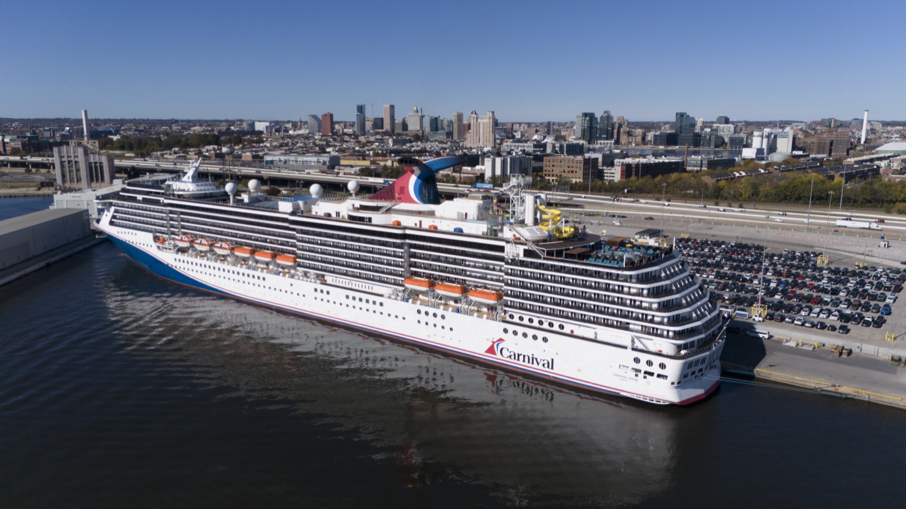大型邮轮停靠Baltimore Cruise Maryland码头、岸边停车区与Baltimore城市天际线实景