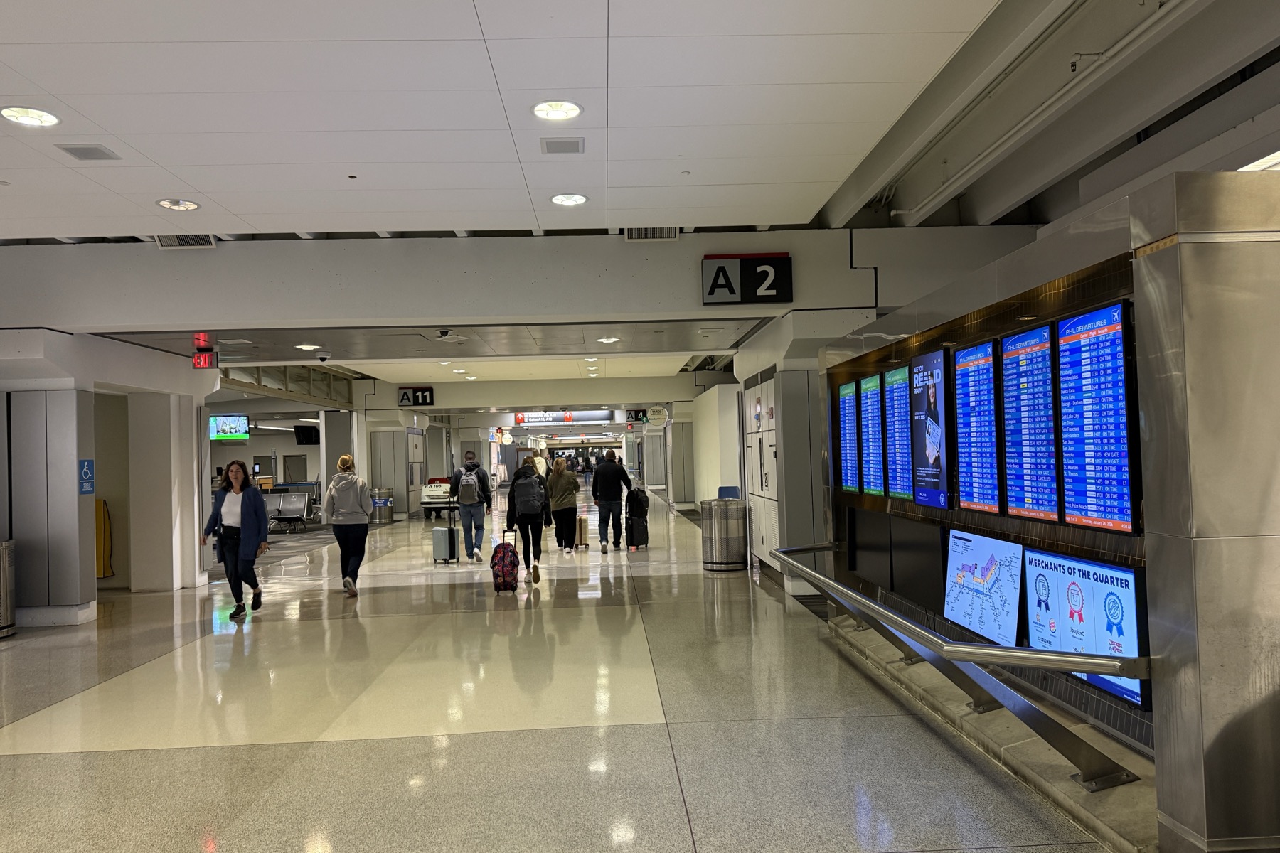 费城国际机场PHL航站楼内A区指示牌、航班屏与携带行李旅客实景